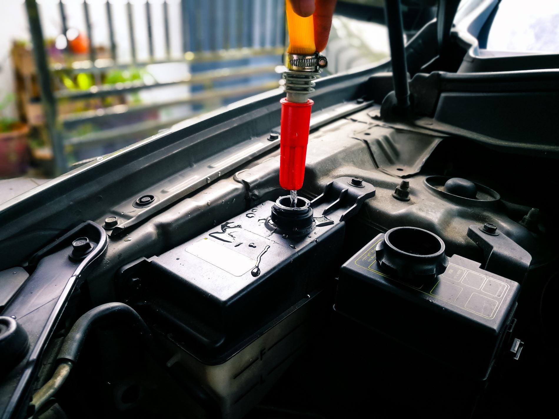 Mechanic adding distilled water into the radiator of new vehicles.